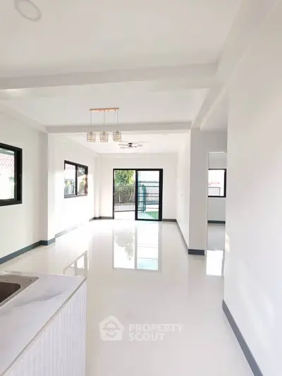 Spacious modern living room with large windows and sleek white flooring