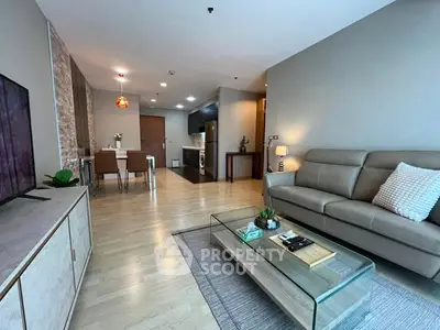 Modern living room with open kitchen, stylish decor, and cozy seating area.