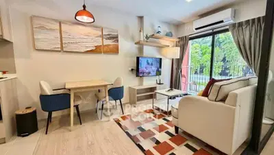 Charming living room with modern decor, cozy seating, and natural light from large windows.