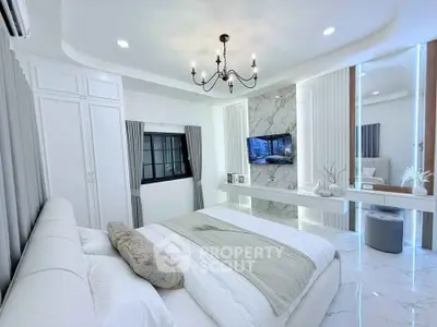 Luxurious modern bedroom with elegant chandelier and marble accents.