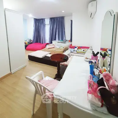 Spacious bedroom with multiple beds and modern furnishings, ideal for family living.