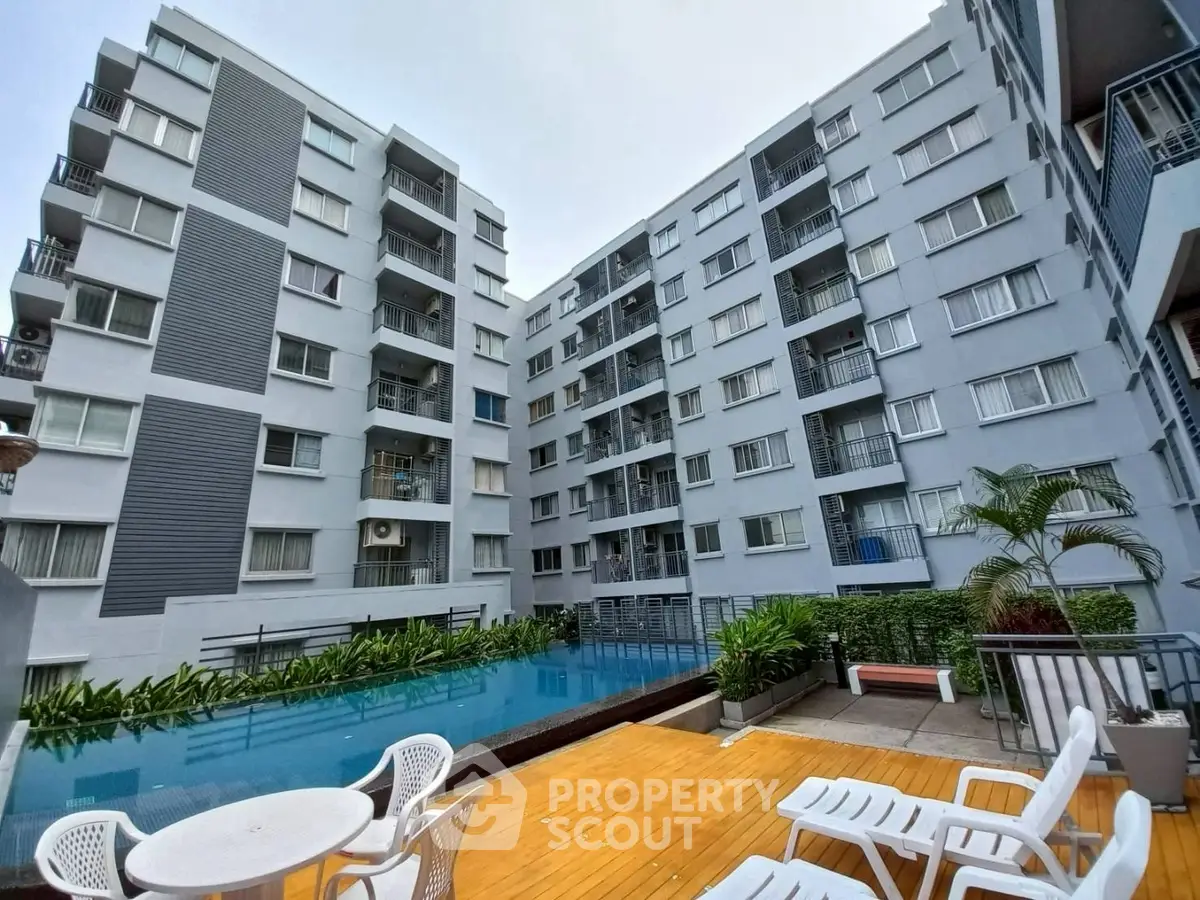 Modern apartment complex with pool and outdoor seating area, perfect for urban living.