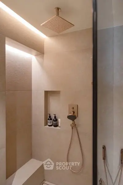 Luxurious modern bathroom with elegant shower design and built-in shelving.