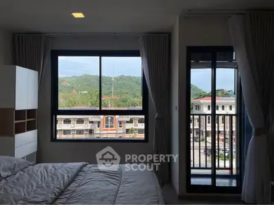Modern bedroom with scenic view and balcony access in a stylish apartment.