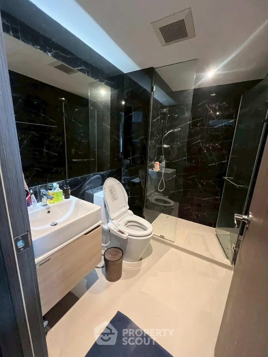 Modern bathroom with sleek black tiles and glass shower enclosure