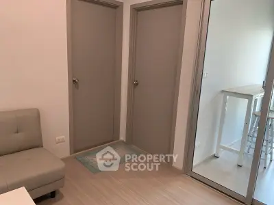 Modern apartment interior with sleek doors and cozy seating area.