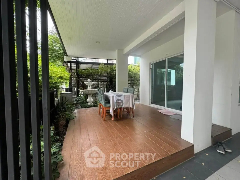 Charming patio with wooden deck and garden view, perfect for outdoor dining and relaxation.