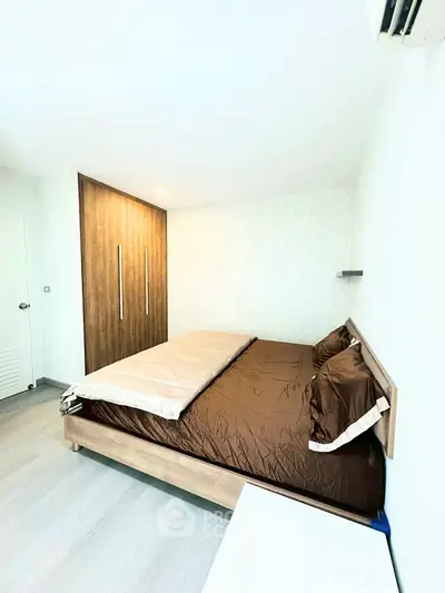 Modern bedroom with stylish wooden wardrobe and cozy bedding