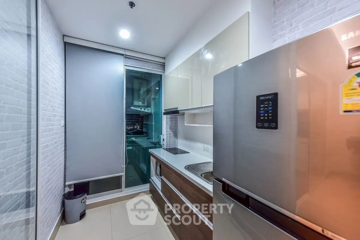 Modern kitchen with sleek appliances and stylish cabinetry in a contemporary apartment.