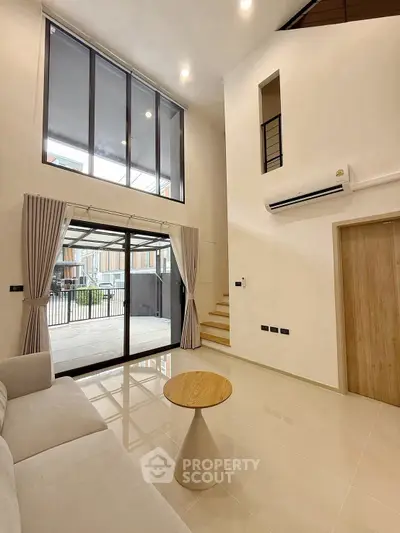 Spacious modern living room with high ceiling and large windows