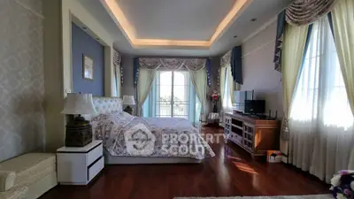 Luxurious bedroom with elegant decor and large windows offering natural light
