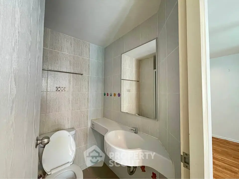Modern bathroom with sleek fixtures and neutral tiles in a contemporary home.