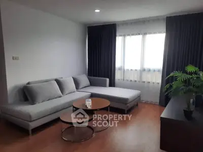 Modern living room with stylish gray sectional sofa and elegant curtains