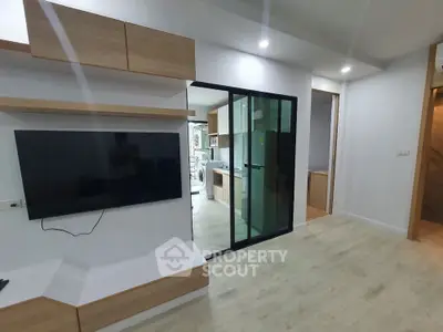 Modern living room with sleek TV setup and open kitchen view