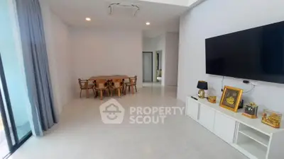 Spacious modern living room with elegant dining area and large TV setup.