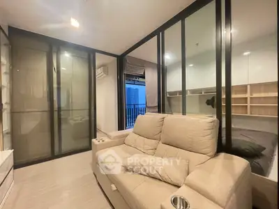 Modern living room with glass partition and cozy beige sofa in a stylish apartment