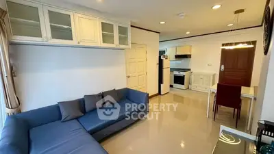 Spacious living room with modern kitchen in open layout, featuring sleek furniture and ample natural light.
