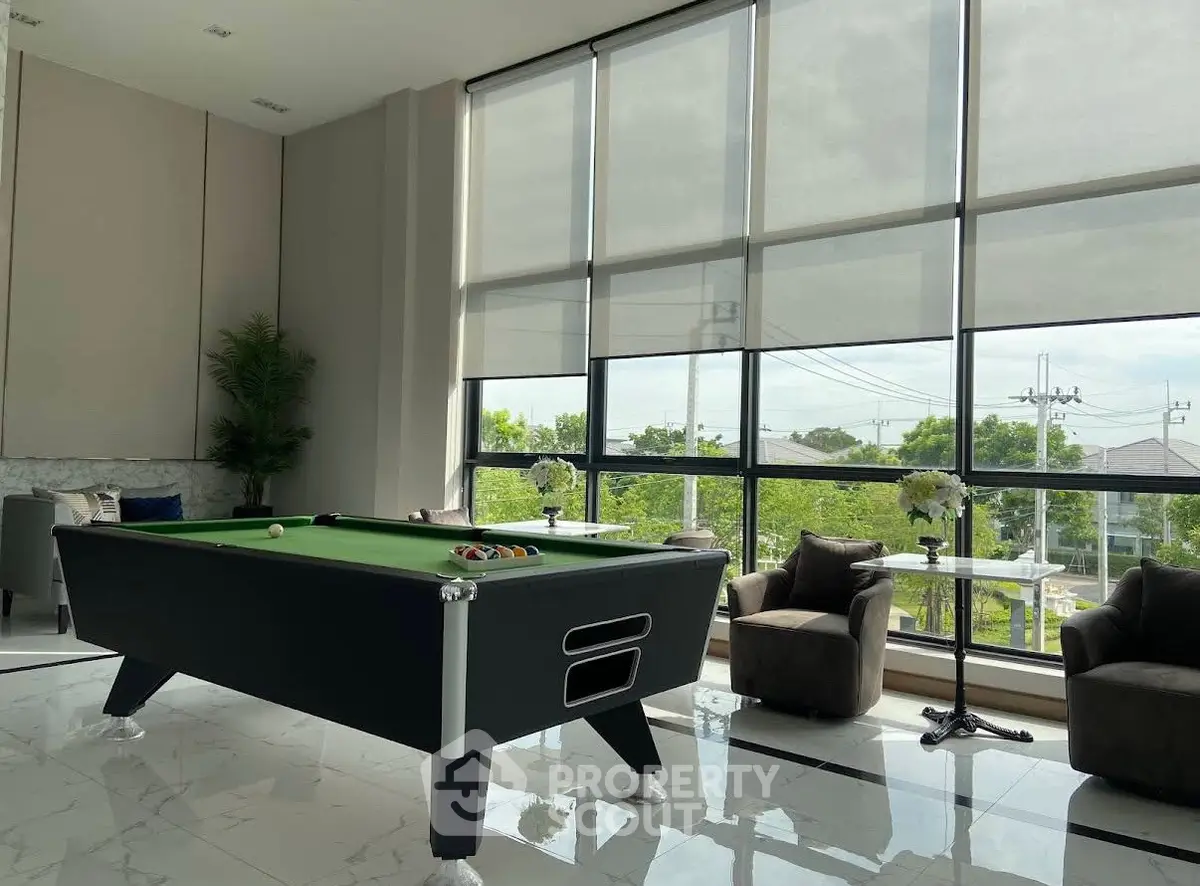 Luxurious common area with pool table and large windows offering scenic views, perfect for relaxation and entertainment.