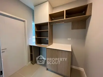 Modern storage room with sleek wooden cabinetry and ample shelving space.