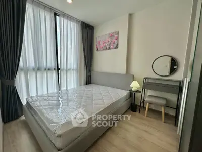 Modern bedroom with stylish decor and natural light, featuring a cozy bed and elegant furnishings.