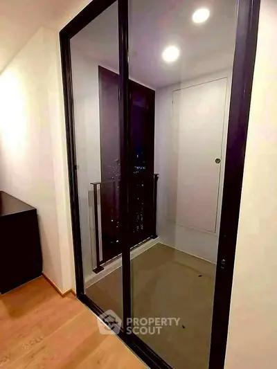 Modern apartment balcony with glass sliding doors and city view