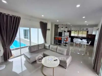 Spacious modern living room with pool view and sleek kitchen design