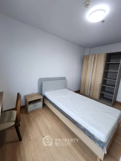 Modern minimalist bedroom with wooden flooring and sleek furniture