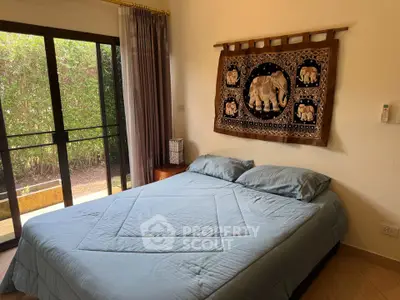 Cozy bedroom with large window and elephant tapestry decor