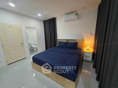 Modern bedroom with ensuite bathroom, featuring sleek design and ambient lighting.