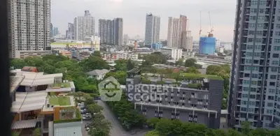 Stunning cityscape view from high-rise apartment with lush greenery and modern buildings.