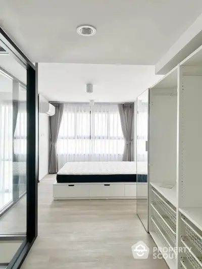 Modern minimalist bedroom with large windows and built-in storage