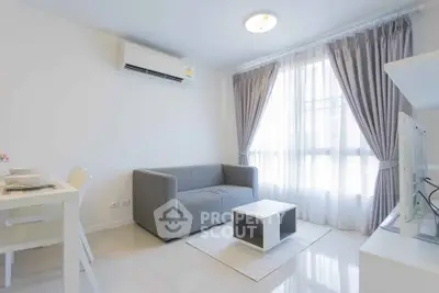 Bright modern living room with sleek furniture and large window, perfect for cozy urban living.