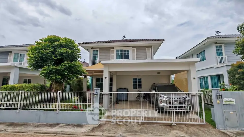 Charming two-story house with a carport and lush greenery in a serene neighborhood.