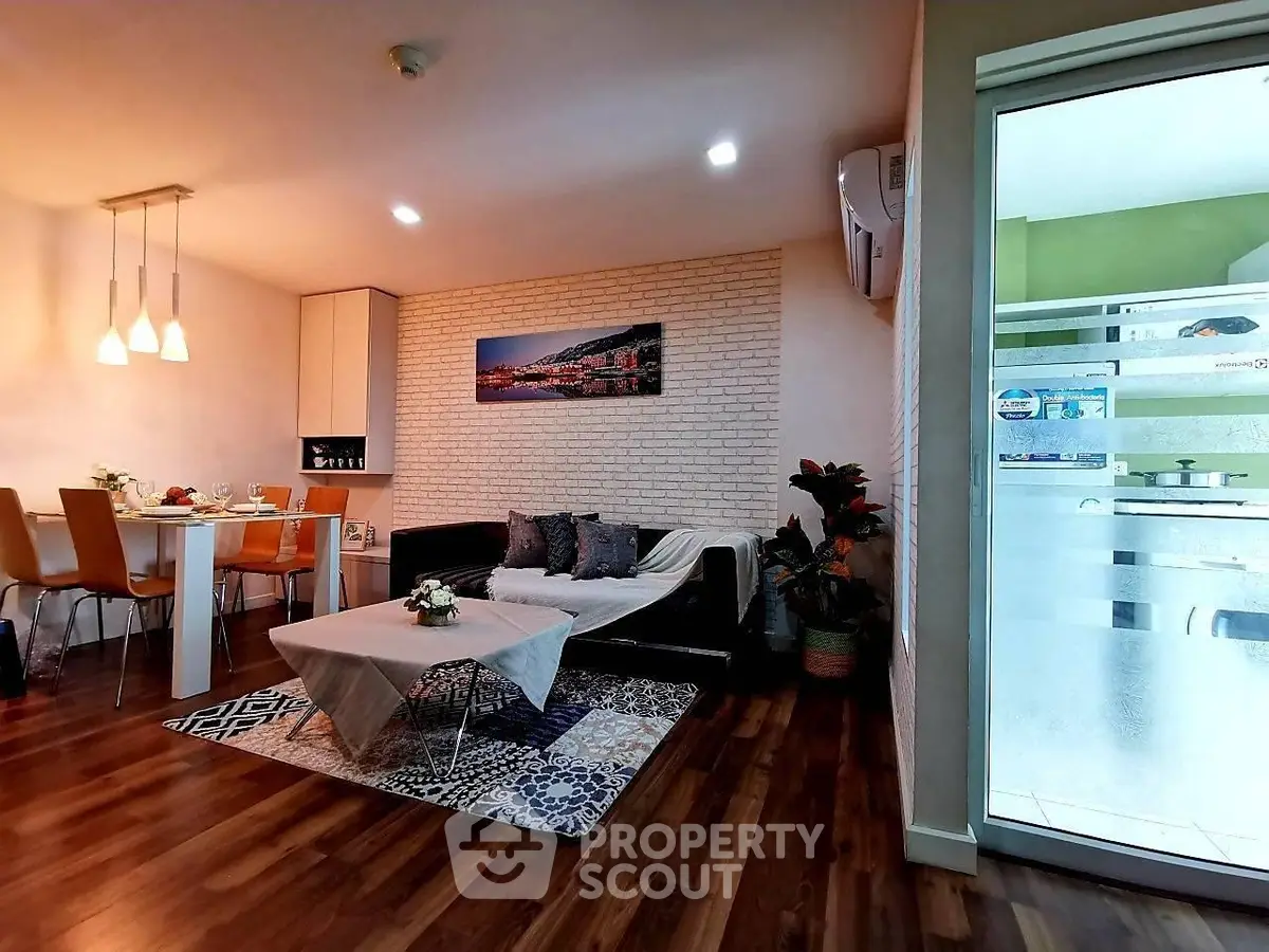 Modern living room with stylish decor and dining area, featuring wooden flooring and cozy lighting.
