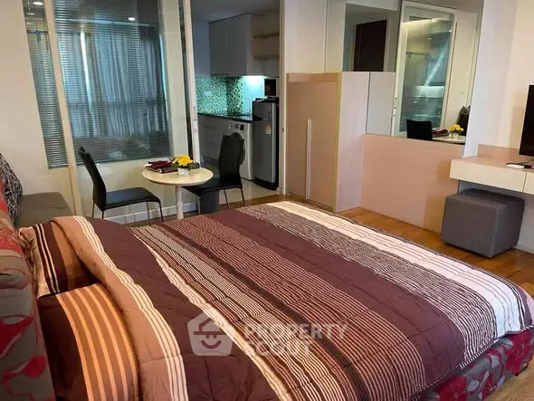 Cozy studio apartment with modern kitchen and dining area, featuring stylish decor and ample natural light.