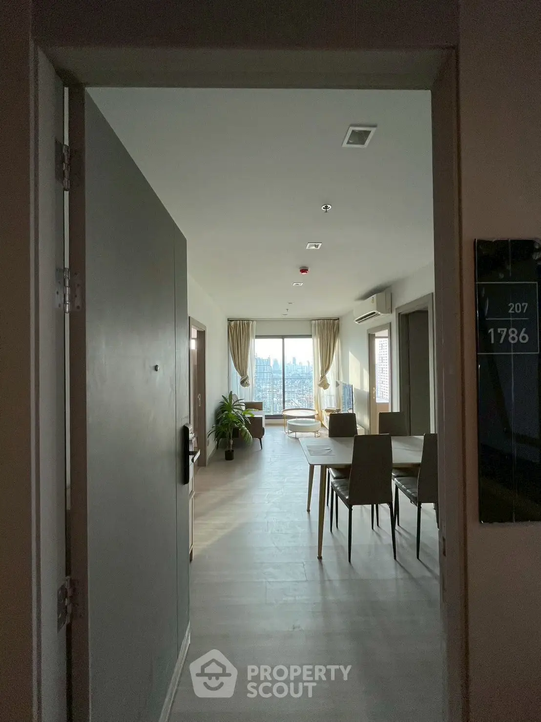 Spacious modern living room with large windows and elegant dining area