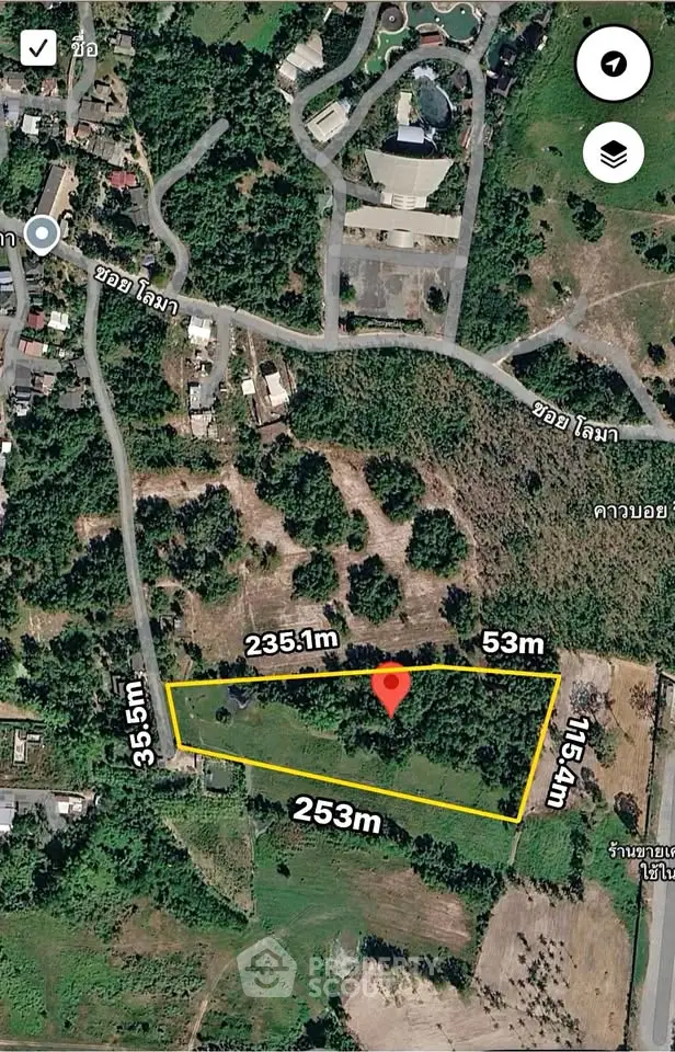 Aerial view of a large plot of land with boundary measurements in a lush green area.