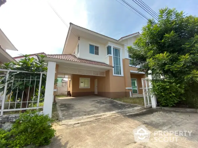 Charming two-story family home with a spacious driveway and lush greenery, featuring a welcoming entrance and large windows for ample natural light.