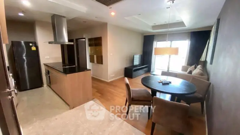 Modern open-layout kitchen and living area with stylish furniture and natural light.