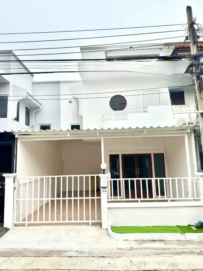 Modern white townhouse with gated parking and stylish facade