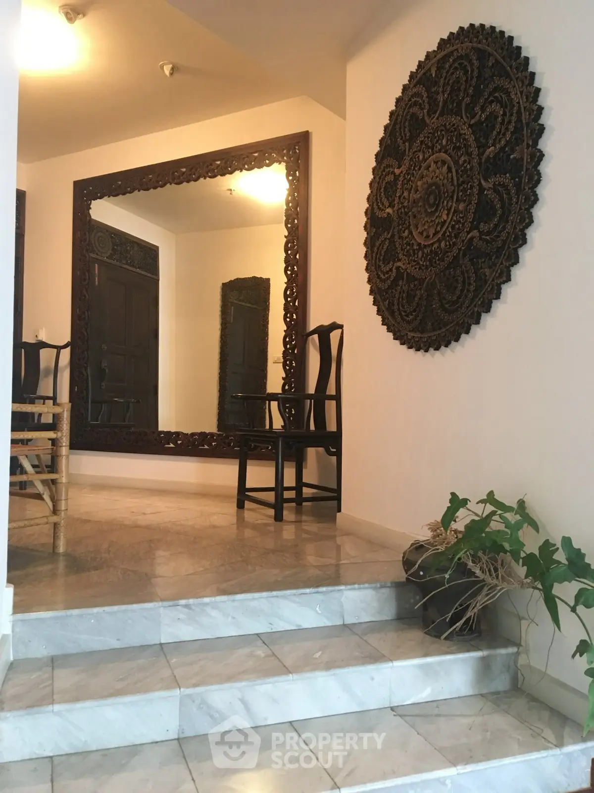 Elegant entrance with decorative mirror and intricate wall art in a stylish home