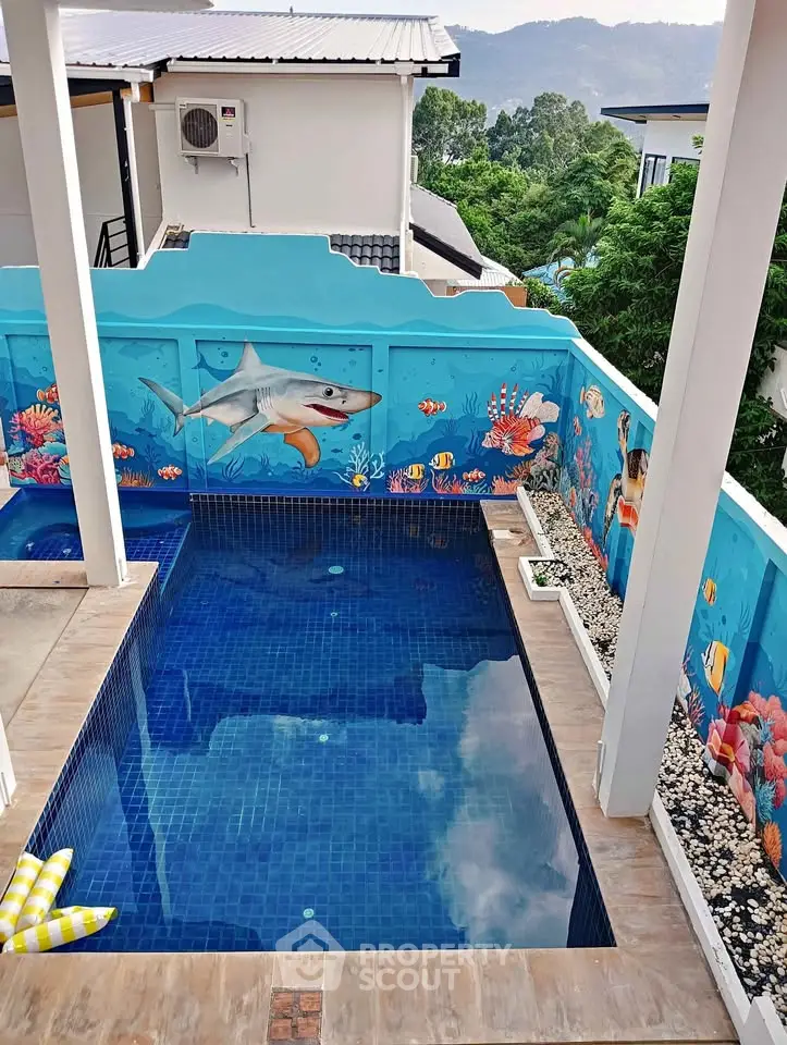 Stunning private pool with vibrant ocean-themed mural and scenic mountain view