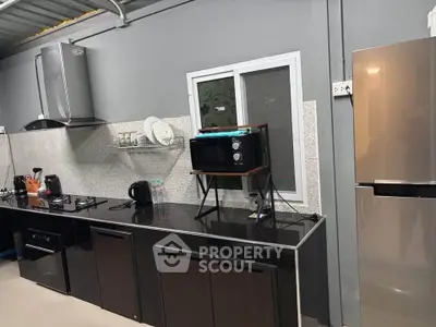Modern kitchen with sleek black countertops, stainless steel appliances, and ample storage space.