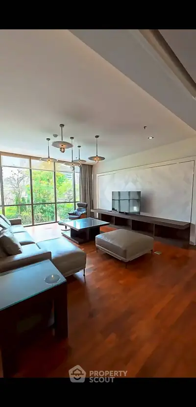 Spacious living room with modern decor and large windows offering a scenic view.