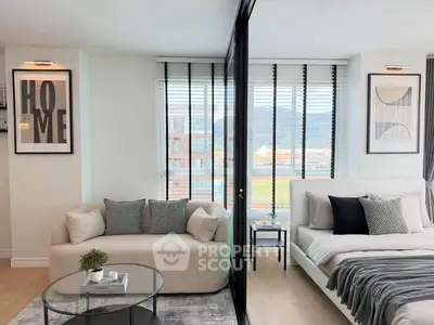 Modern living room and bedroom with stylish decor and large windows offering scenic views.
