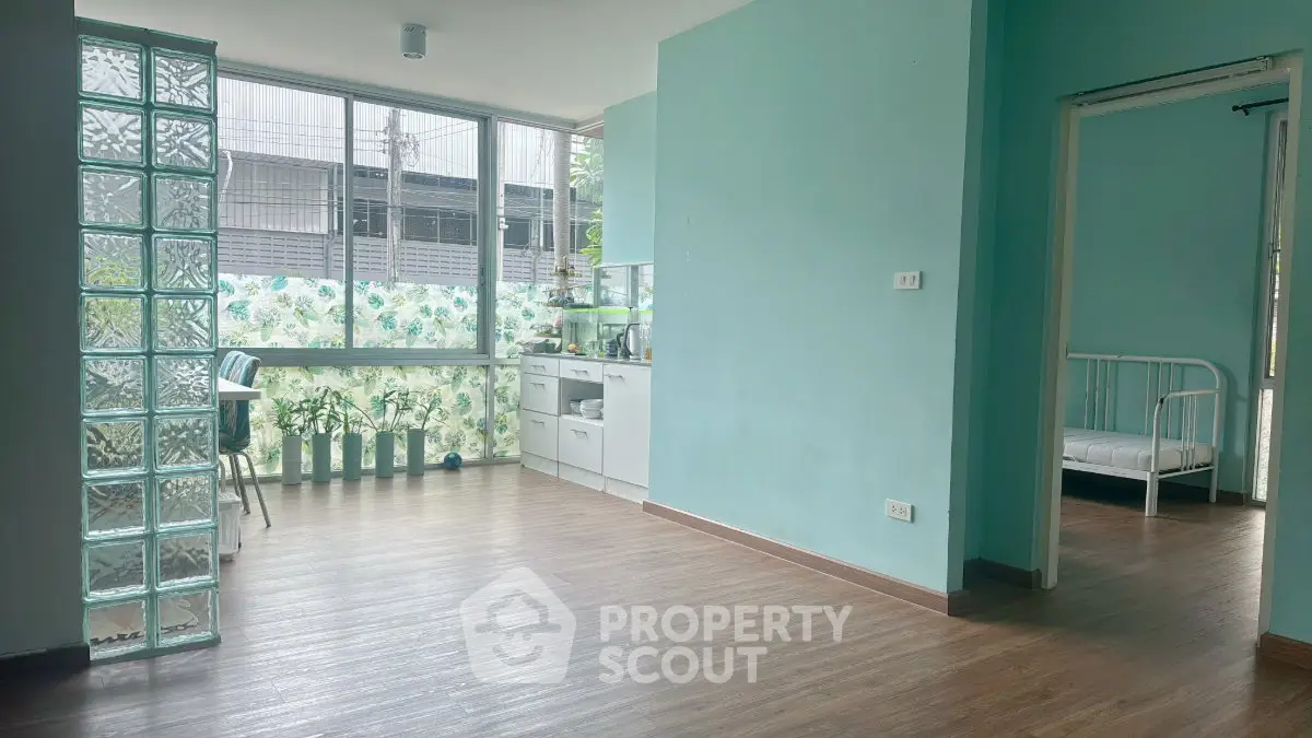 Spacious living area with large windows and modern decor, perfect for natural light lovers.