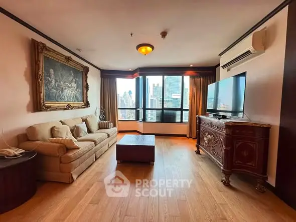 Luxurious living room with elegant decor and stunning city view, featuring a comfortable sofa and large TV.