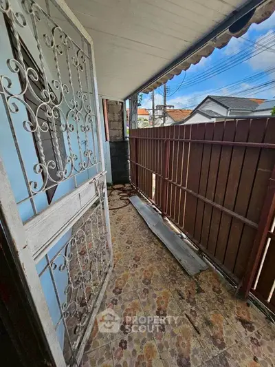 Charming balcony with vintage wrought iron door and floral tile flooring, perfect for relaxing outdoors.