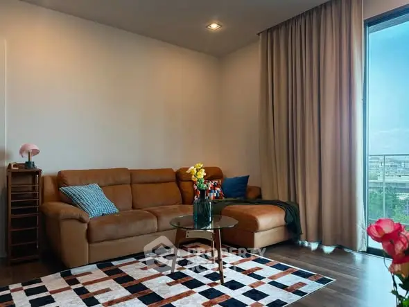 Stylish living room with leather sofa and city view balcony, perfect for modern urban living.