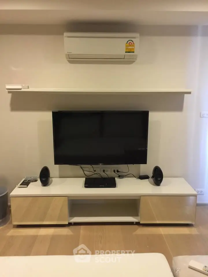 Modern living room with sleek TV setup and air conditioning unit.